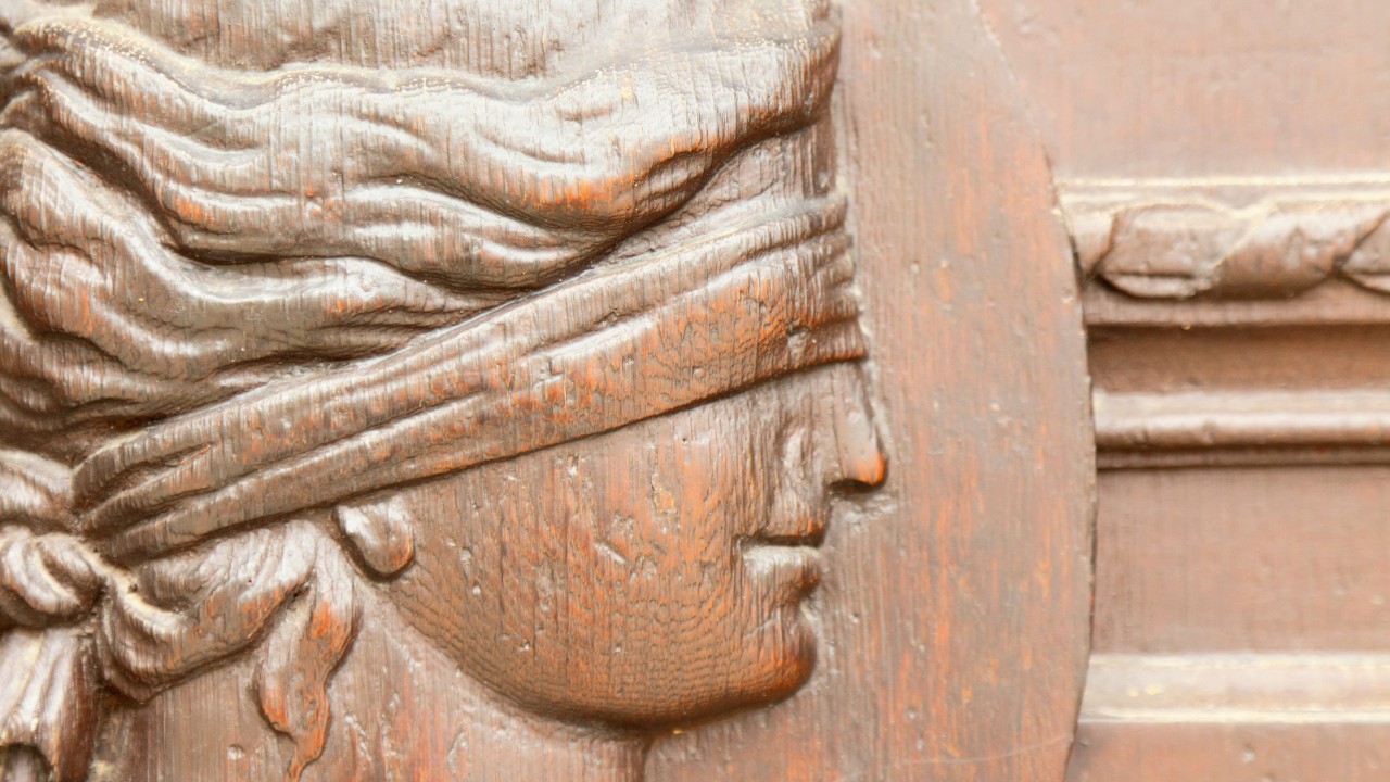Ein altes Wandrelief von Justizia mit verbundenen Augen